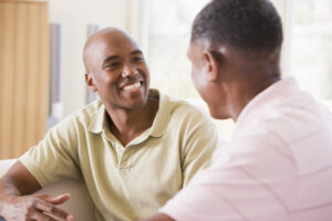 Two men in living room talking and smiling